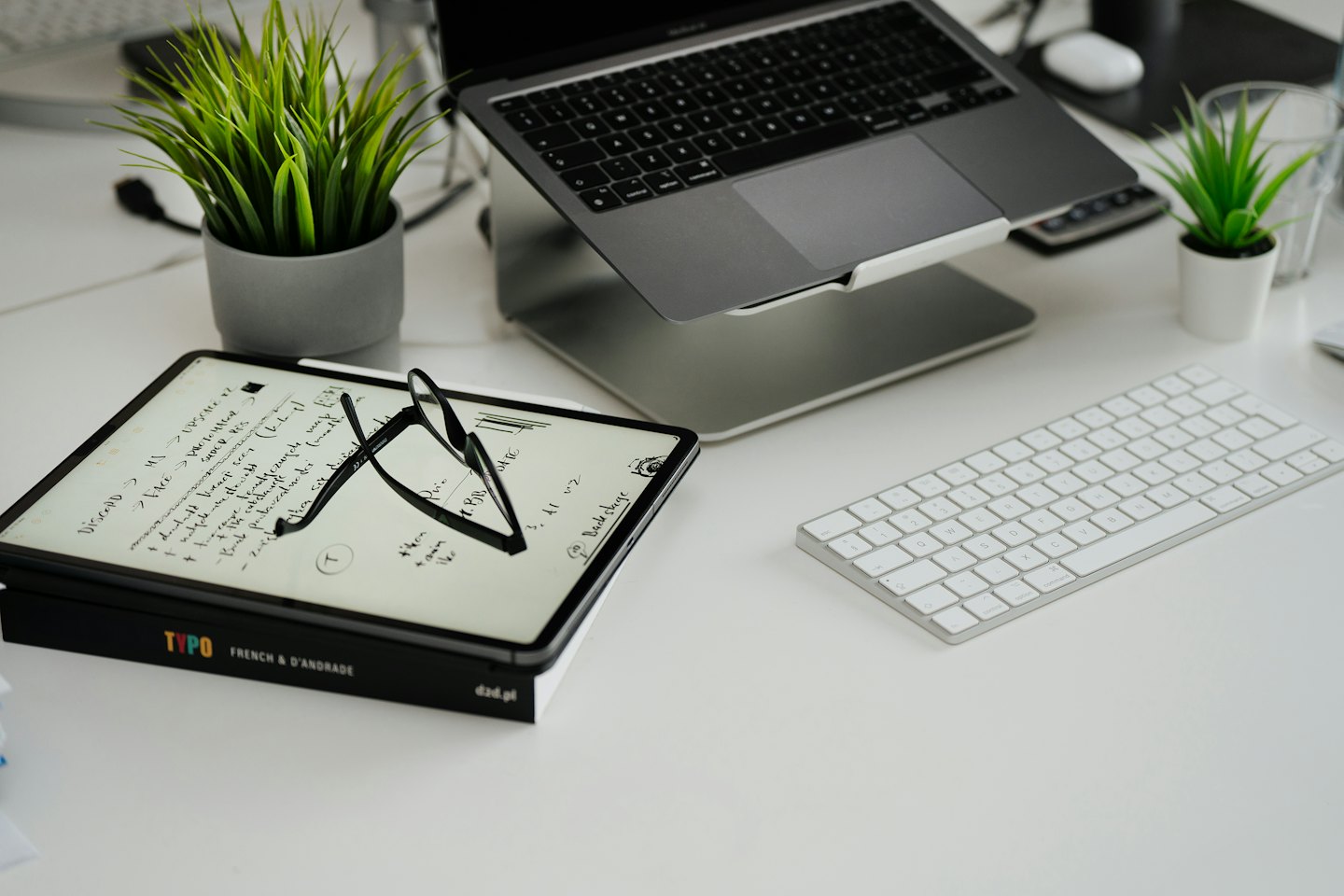 Laptop und Tablet auf einem sauberen, organisierten, modernen Schreibtisch.